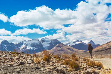 Huascarn Ulusal Parkı, Huaraz / Peru 'daki Pastoruri buzuluna giden And Dağları' ndaki patikada yürüyen bir kadın. Tropik buzullar deniz seviyesinden 5200 metre yükseklikte..