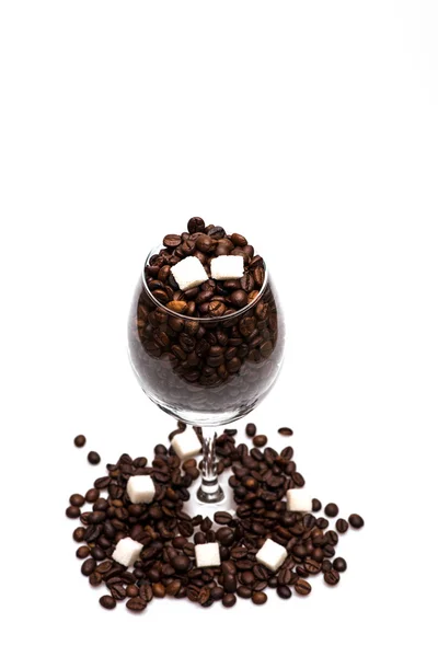 Kávová zrna a kostky cukru uvnitř sklenice na víno — Stock fotografie