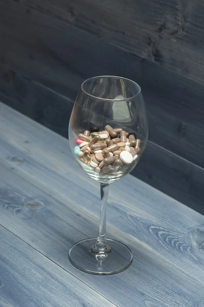 Cápsulas y tabletas médicas dentro del vaso de vino — Foto de Stock