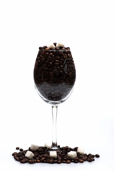 Kaffebönor och sockerbitar innanför glas vin — Stockfoto