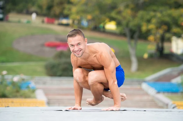 Hombre atlético haciendo asanas de yoga en el parque — Foto de Stock