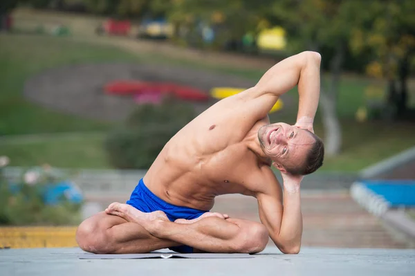 Homme athlétique faisant du yoga asanas dans le parc — Photo