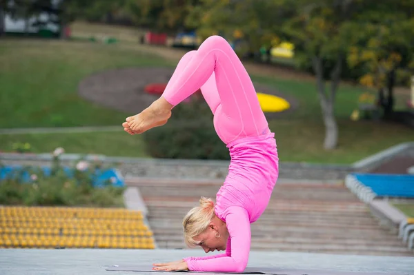 Söt ung kvinna som gör yoga asanas i parken — Stockfoto