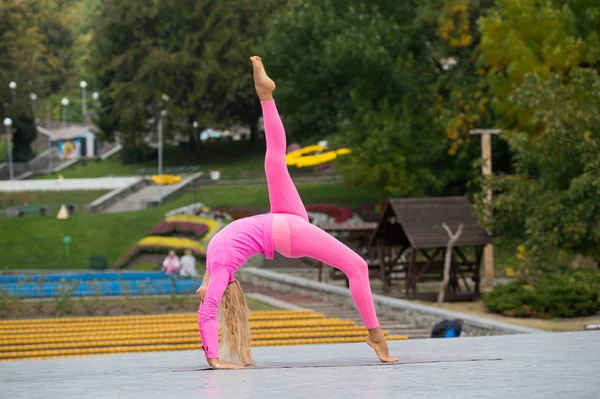 Hezká mladá žena dělá jógu asanas v parku — Stock fotografie