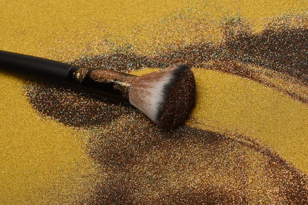 Kosmetika pensel på gyllene bakgrund — Stockfoto