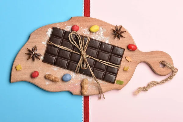 Dark chocolate bar on cutting board — Stock Photo, Image