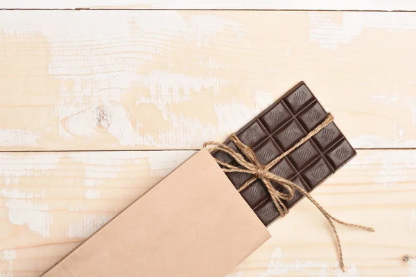 Dark chocolate bar on vintage wooden background — Stock Photo, Image
