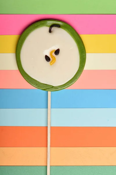 Pirulito como maçã verde no fundo colorido — Fotografia de Stock