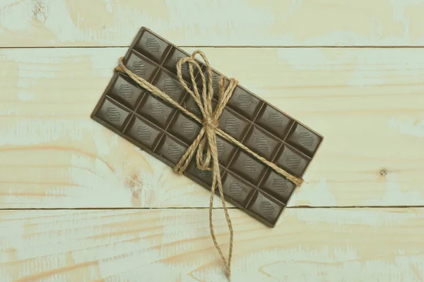 Dark chocolate bar on vintage wooden background — Stock Photo, Image