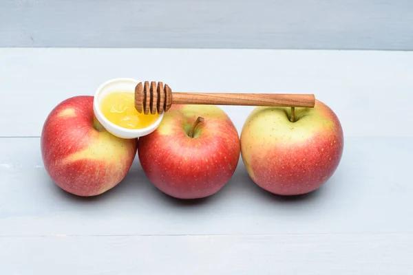 Яблоки с медом и палкой — стоковое фото
