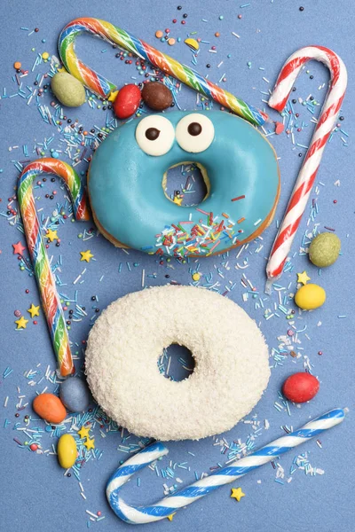 Смешные глазурованные пончики на синем фоне — стоковое фото