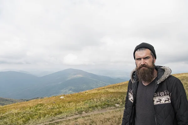 Man hipster traveler with beard and moustache portrait on mountain — Stock Photo, Image