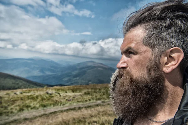 Man hipster traveler with beard and moustache portrait on mountain — Stock Photo, Image