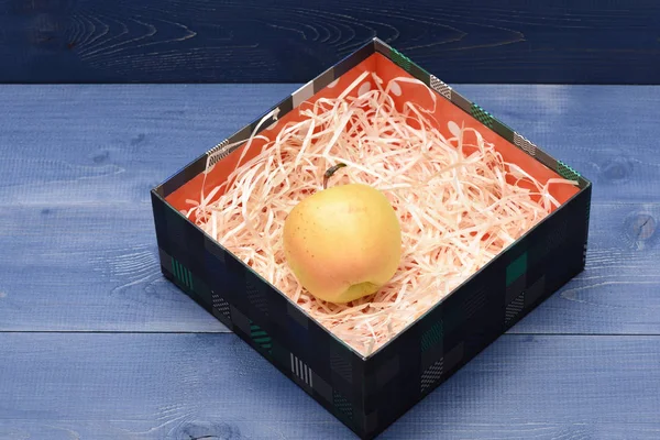 Green apple inside present box