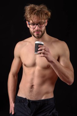 Sakallı seksi adam elinde kahve tutuyor.