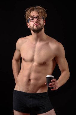 Sakallı seksi adam elinde kahve tutuyor.