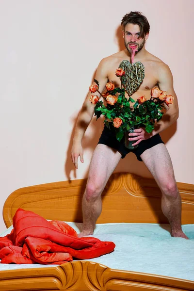 Vousatý macho muž s růžemi — Stock fotografie