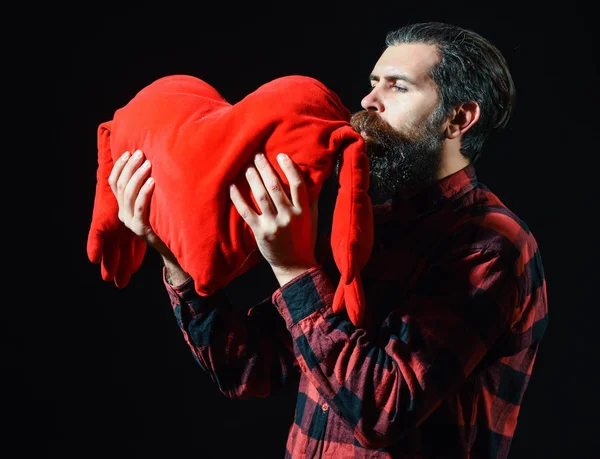 Бородатий чоловік цілує серцеву подушку — стокове фото