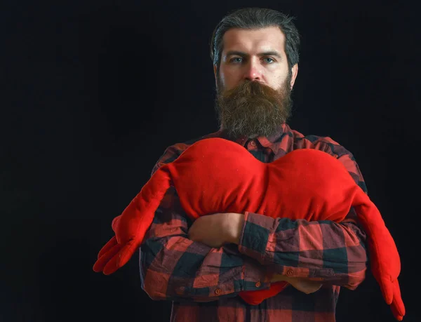 Homem barbudo com travesseiro de coração — Fotografia de Stock