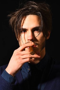 Ciddi sakallı adam puro içiyor.