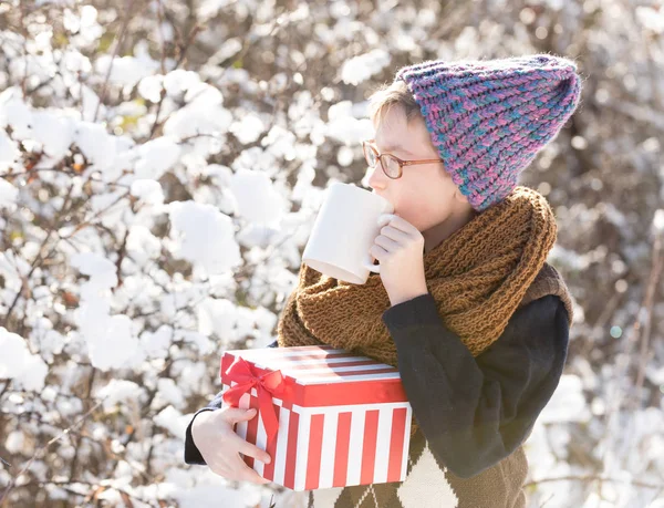 Маленький мальчик с подарком и кубок зимой на открытом воздухе — стоковое фото