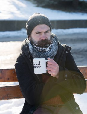 Kaşlarını çatan adam bardaktan içer.