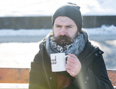 Kaşlarını çatan adam bardaktan içer.