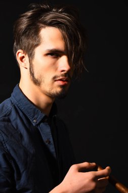 Sigara içen ciddi sakallı bir adam.