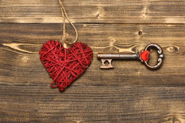 Kırmızı kalp ve Sevgililer dekorasyon olarak ahşap üzerine metalik anahtar