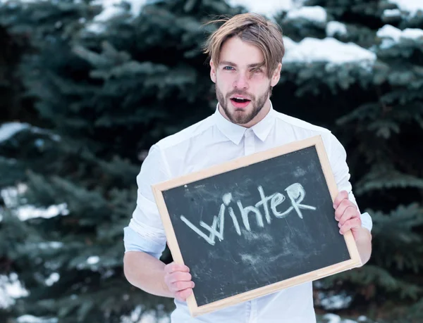 Handsome man with winter blackboard outdoor — Stock Photo, Image
