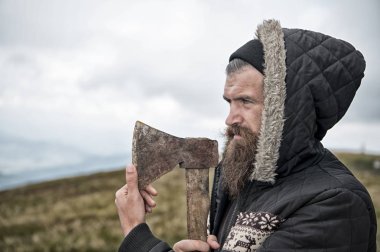 Sakallı yakışıklı ciddi adam dağ üstüne paslı balta ile