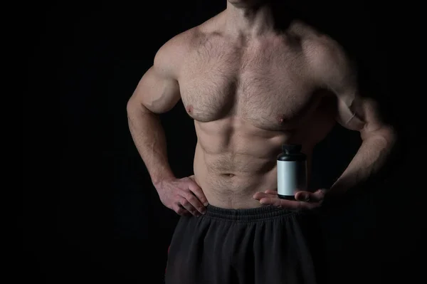Bonito sexy atleta homem com muscular corpo mantém esteroide jar — Fotografia de Stock