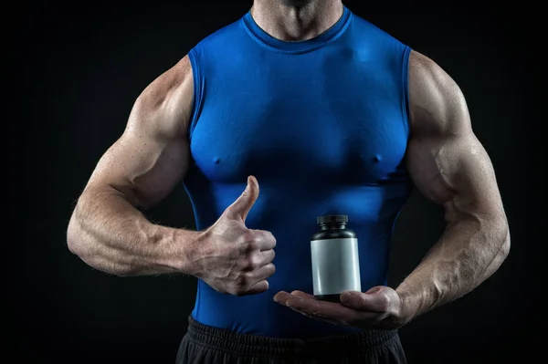 Bello uomo atleta sexy con il corpo muscolare tiene vaso di steroidi — Foto Stock
