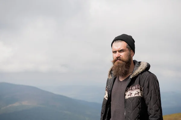 Barbudo bonito sério homem no topo da montanha — Fotografia de Stock