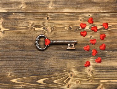 Kırmızı kalp ve Sevgililer dekorasyon olarak ahşap üzerine metalik anahtar