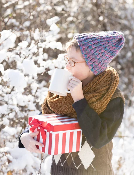 Niño pequeño con regalo y copa en invierno al aire libre — Foto de Stock