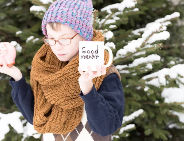 Kışın açık havada elinde kupa ve para kutusu olan küçük bir çocuk. — Stok fotoğraf