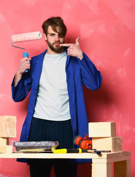 Constructor hombre sosteniendo rodillo de pintura —  Fotos de Stock