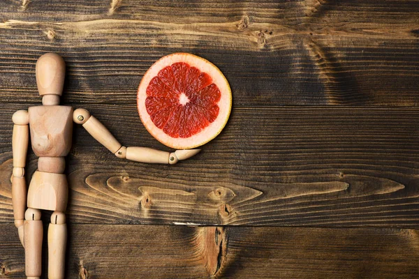 Grapefruit szeletek gazdaság fabáb — Stock Fotó