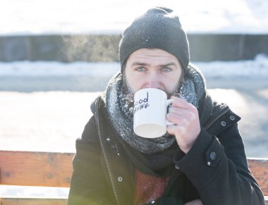 Kaşlarını çatan adam bardaktan içer.