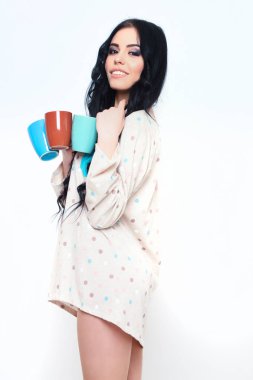 Beyaz kahve fincanlarıyla gülümseyen güzel seksi kız.