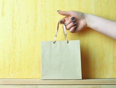 Sarı duvar el ışık mavi alışveriş çantasında