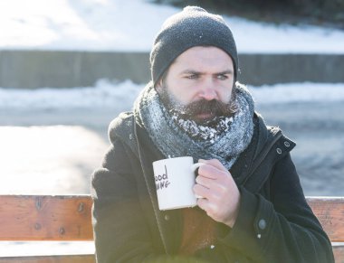 Kaşlarını çatan adam bardaktan içer.