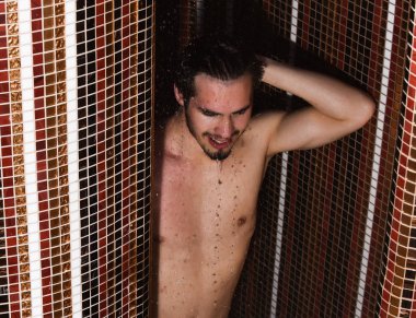 Yakışıklı kaslı seksi adam duşta yıkanıyor.