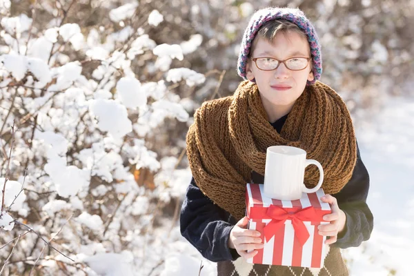 Petit garçon avec cadeau et tasse en hiver en plein air — Photo