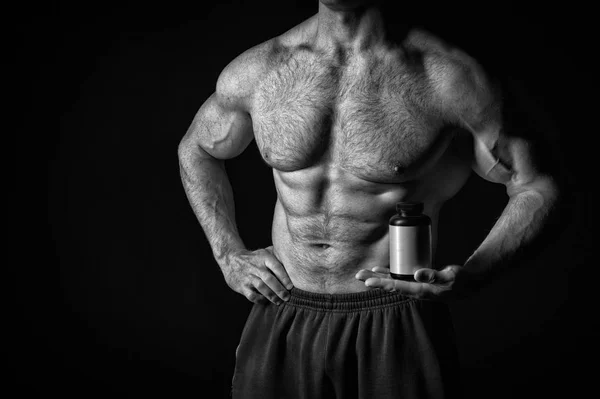 Handsome sexy athlete man with muscular body holds steroid jar — Stock Photo, Image