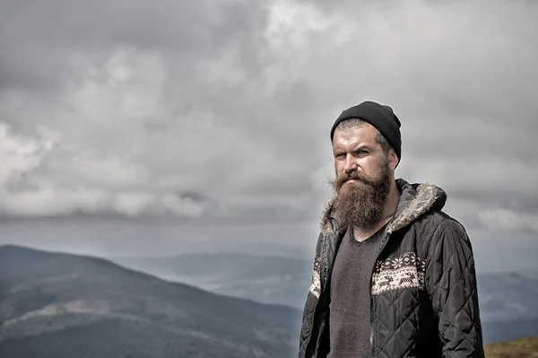 Barbudo bonito sério homem no topo da montanha — Fotografia de Stock