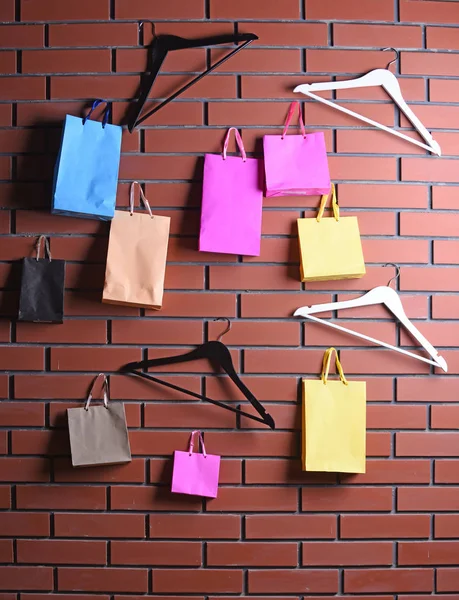 Colorido bolso de compras y percha armario en la pared de ladrillo marrón — Foto de Stock