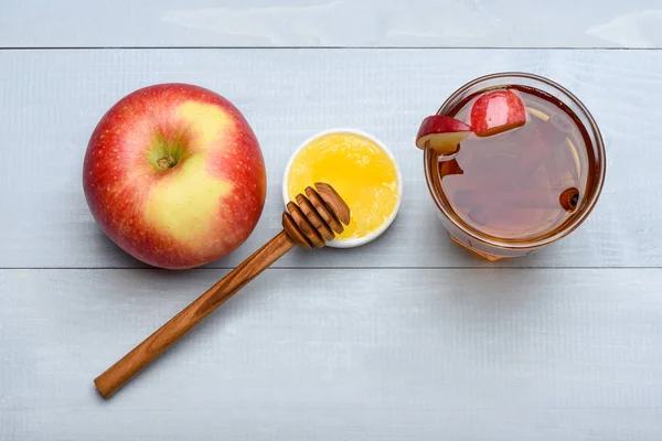 Bicchiere con succo, pezzetti di mela, cannella, miele, bastoncino di miele — Foto Stock