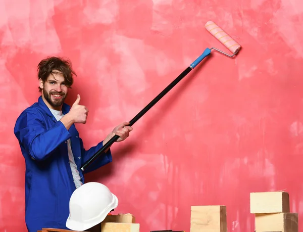 Hombre sonriente sosteniendo el rodillo de pintura — Foto de Stock